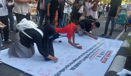 Foto: Sejumlah warga membubuhkan tanda tangan pada kain petisi yang digelar oleh KEPAK NTB di kawasan Car Free Day Taman Udayana, Mataram, Minggu (26/4/2026), sebagai bentuk dukungan terhadap pengusutan dugaan kasus gratifikasi DPRD NTB dan desakan pemanggilan Gubernur NTB sebagai saksi kunci.(JD09)