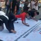 Foto: Sejumlah warga membubuhkan tanda tangan pada kain petisi yang digelar oleh KEPAK NTB di kawasan Car Free Day Taman Udayana, Mataram, Minggu (26/4/2026), sebagai bentuk dukungan terhadap pengusutan dugaan kasus gratifikasi DPRD NTB dan desakan pemanggilan Gubernur NTB sebagai saksi kunci.(JD09)
