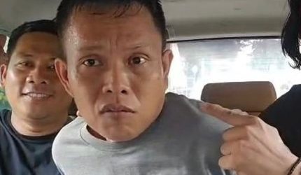 Foto: Pelaku berinisial FR alias DR (tengah), saat diamankan oleh aparat kepolisian setelah ditangkap di Pelabuhan Tanjung Perak, Surabaya. Ia diduga menjadi pelaku penyekapan dan pemerkosaan terhadap seorang mahasiswi di Makassar dengan modus lowongan kerja palsu.