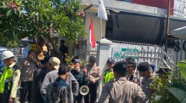 Foto: Massa dari Koalisi Rakyat Sipil (KRS) NTB menyampaikan orasi dengan pengawalan ketat aparat kepolisian di depan Kantor PT Amman Mineral Nusa Tenggara (AMNT) di Mataram, Kamis (6/8/2026).