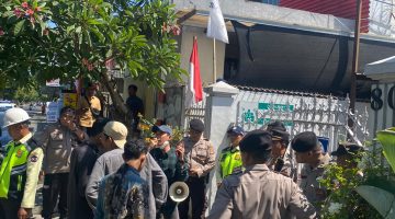 Foto: Massa dari Koalisi Rakyat Sipil (KRS) NTB menyampaikan orasi dengan pengawalan ketat aparat kepolisian di depan Kantor PT Amman Mineral Nusa Tenggara (AMNT) di Mataram, Kamis (6/8/2026).
